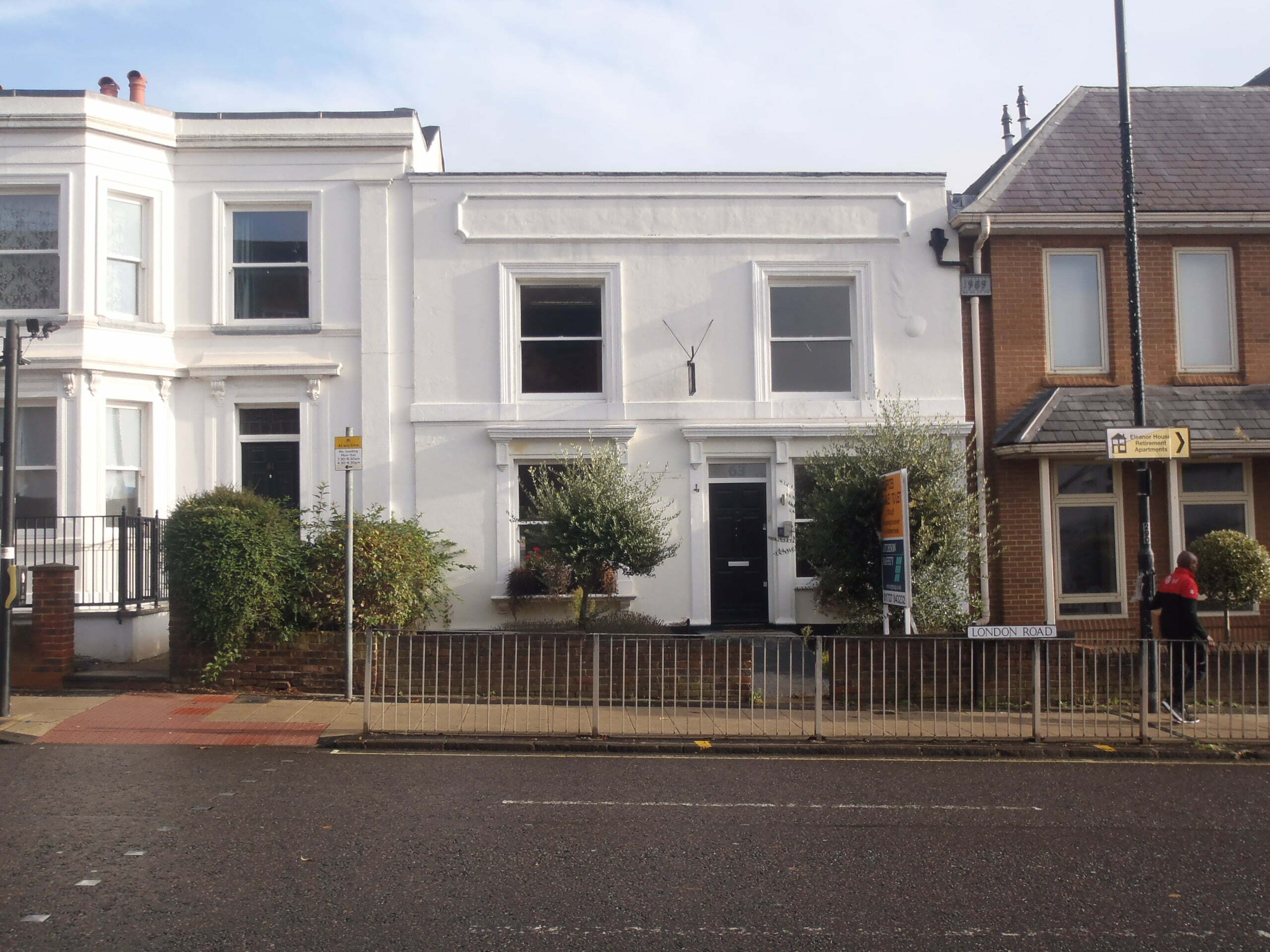The front of an office building that as once a home but now converted, alongside other properties on the street